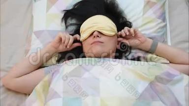 顶部的年轻女子戴着睡眠面具准备睡眠，白天睡眠和放松。 生活方式和人